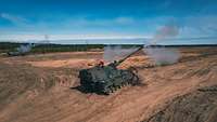 Zwei Panzerhaubitzen 2000 stehen parallel zu einander und verschießen ihre Munition.