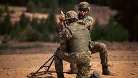 Zwei kroatische Soldaten knien vor einer Mörsergranate.