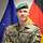 Ein Soldat steht vor einer NATO- und einer Deutschland-Flagge.