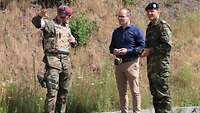 Zwei Soldaten und ein Mann im Gespräch. 