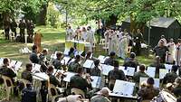 Soldaten sitzen auf Stühlen und hören einem Gottesdienst zu