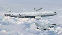Zwei Eurofighter begleiten einen Airbus am Himmel