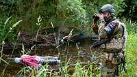 Soldat fotografiert den nachgestellten Tatort eines Kriegsverbrechens.