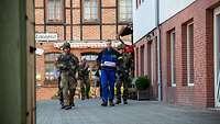 Soldaten begleiten eine Zivilperson