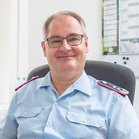 Ein Soldat sitzt an einem Schreibtisch mit einem Monitor darauf