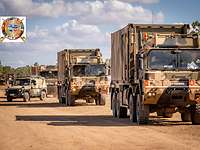 Die australische Truppe rollt zur Übung Konvoi aus militärischen Fahrzeugen auf einer Sandstraße