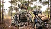 Two soldiers squatting in the forest