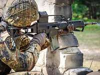 Ein Soldat mit dem Gewehr G36 in Stellung hinter einer Mauer
