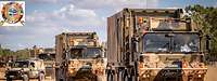 Convoy of military vehicles on a sand road 