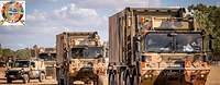 Convoy of military vehicles on a sand road 