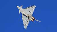 Eurofighter mit Nachbrenner Auf dem Foto ist ein Kampfjet von unten in der Luft zu sehen. Der Nachbrenner ist eingeschaltet.