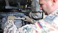 Ein Soldat arbeitet am Motor eines Stromaggregats.