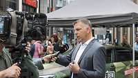 Thorsten Roth in der Kölner Fußgängerzone im Gespräch mit Medien