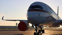 Ein Airbus A350-900 steht auf dem Flugfeld bei Sonnenaufgang