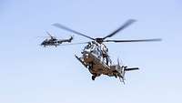 Zwei Hubschrauber befinden sich leicht versetzt in der Luft. 