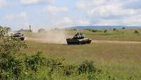 Mehrere Panzer bewegen sich entlang eines Weges.