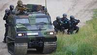 Ein Soldat und fünf Polizeiangehörige beobachten