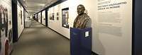 Ein langer Gang mit Infotafeln und der Büste eines Mannes