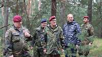 Vier Soldaten und ein Zivilist beobachten den Wettkampf
