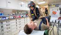 Eine Soldatin kümmert sich um einen Patienten. Beide tragen Uniform.