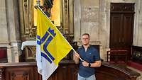 Teilnehmer mit der Fahne der deutschen Katholischen Militärseelsorge vor dem Gottesdienst