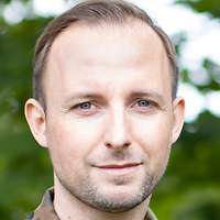 Blick durch ein Fenster in den halbdunklen Innenraum eines Ladens mit verpackter Ausstattung.