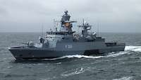 Ein graues Schiff fährt über ein Gewässer