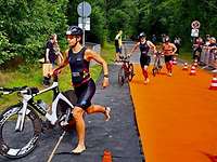 Sportlerinnen und Sportler wechseln vom Rad zum Laufen