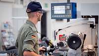 Wiegeposition Ein junger Mann arbeitet an Werkstattmaschinen.