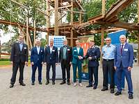 Hochseilgarten Warendorf Projektverantwortliche Gruppenbild mit einer weiblichen und sieben männlichen Personen am Boden eines Hochseilgartens