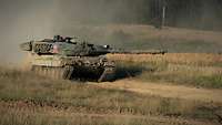 Ein Leopard 2A6 fährt über den Übungsplatz. Hinter ihm steigt eine Staubwolke empor. 