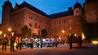Militärorchester vor einem Schloss bei Abendstimmung