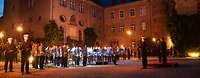 Militärorchester vor einem Schloss bei Abendstimmung
