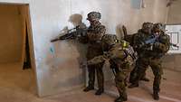 Mehrere Soldaten stehen neben einer offenen Tür, am Körper und auf dem Helm tragen sie Sensoren.