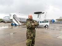 Junger Soldat steht auf dem Rollfeld, im Hintergrund ein E-3A Awacs-Aufklärungsflugzeug der NATO.