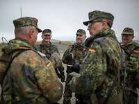 Reservisten bei Lagebesprechung auf dem Truppenübungsplatz Mehrere Soldaten stehen zusammen auf dem Truppenübungsplatz und besprechen sich