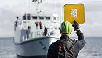 german soldier gives optical signals to an other warship