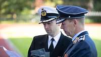 Korvettenkapitän Robert A. und Oberstleutnant Andreas B. stehen auf dem Appellplatz und prüfen den Ablauf