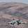 The image shows a Tornado fighter jet taking off in front of a desert landscape.