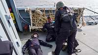 Drei Marinesoldaten auf dem Flugdeck eines Schiffes