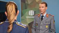 Eine Soldatin spricht mit einem Soldaten in einem Studio während eines Interviews