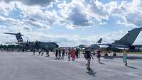 Zwischen Besuchenden des Slovak International Air Fest stehen mehrere Flugzeuge.