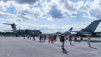 Zwischen Besuchenden des Slovak International Air Fest stehen mehrere Flugzeuge.