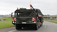 Eine Panzerhaubitze steht auf einem Schwerlasttransporter. Dieser fährt auf der Autobahn.