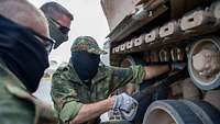 Soldaten arbeiten an einer Panzerkette