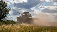 Panzer fährt in Staub gehüllt im Gelände