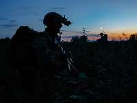 Vorauskräfte sind gelandet. Silhouette eines Soldaten mit Helm, Nachsichtgerät und Rucksack auf dem Rücken in der Abenddämmerung