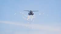Ein Hubschrauber CH-53 in der Luft stößt leuchtende Fackeln aus