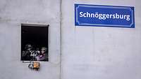 In einem Fenster steht ein Soldat mit einer Waffe in Stellung.