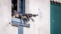 Ein Soldat schießt aus einem Fenster.